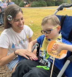 child with Lekotek leader and bubbles